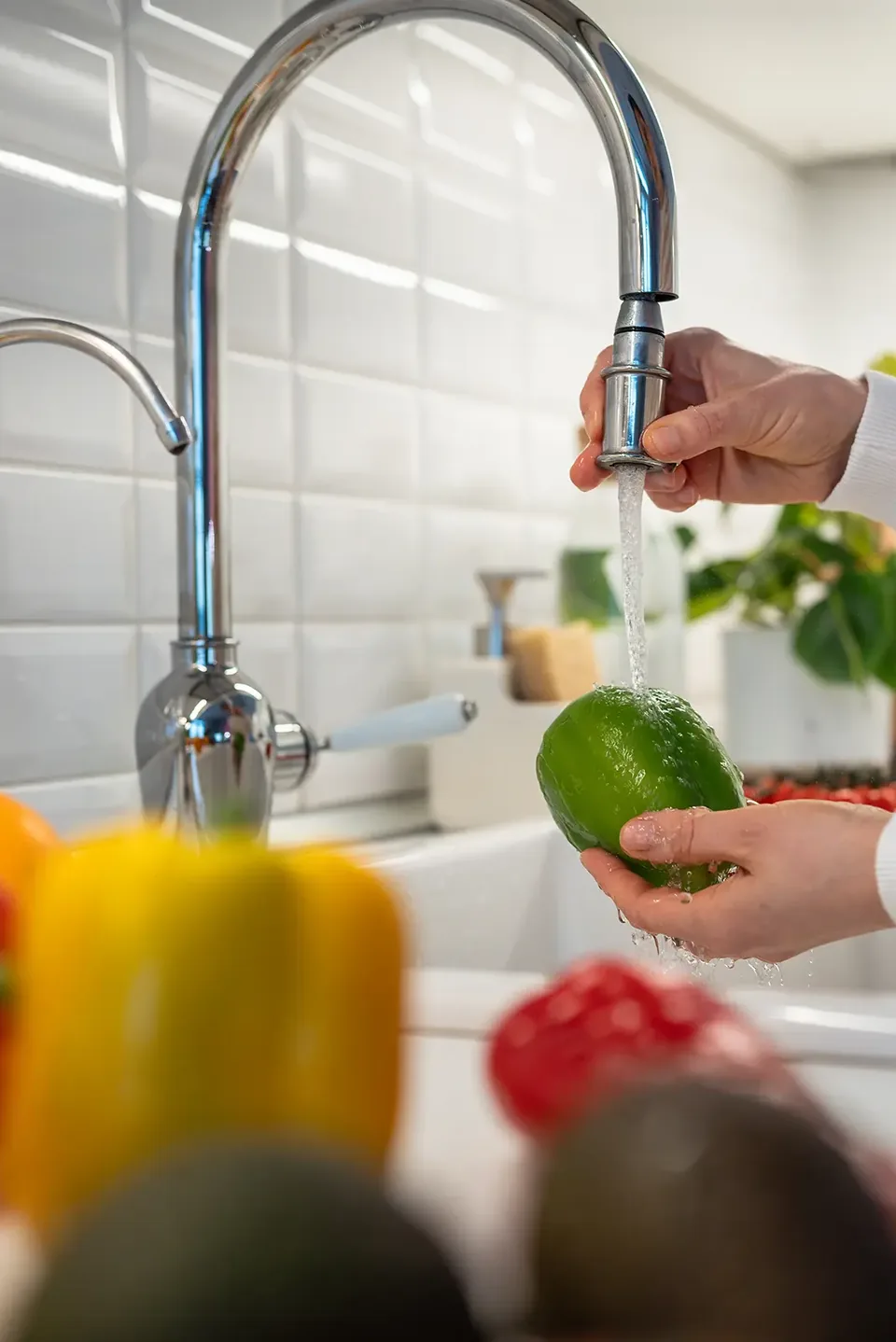 Verdure lavate sotto il rubinetto della cucina